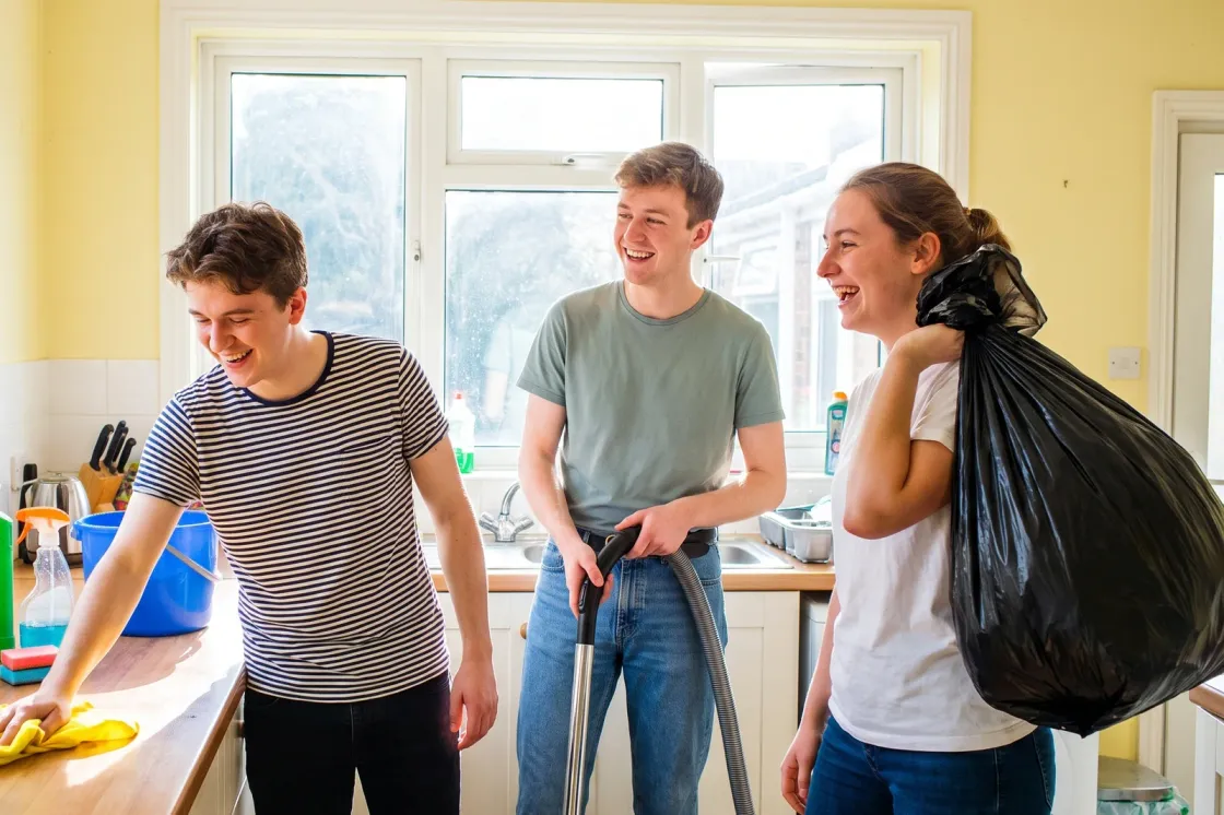 Three housemates cleaning their kitchen together at the end of the tenancy