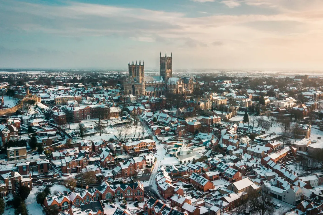 Lincoln under snow at sunrise, rooftops white and the cathedral rising in the middle distance