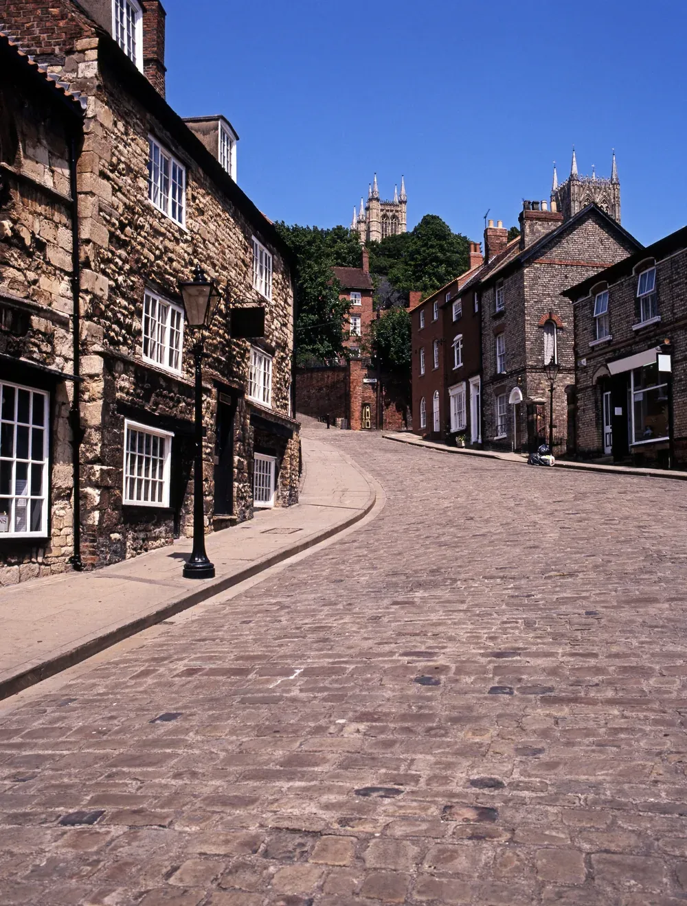 The cobbles of Steep Hill in Lincoln climbing towards the cathedral towers