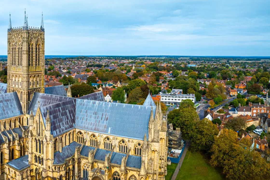 Uphill Lincoln from the air, rooftops and trees spreading north beyond the cathedral